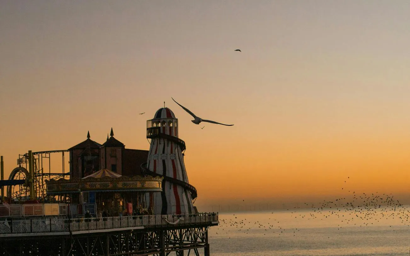 Brighton Pier at sunset with seagulls flying, part of the Gone With the Tide city exploration game.