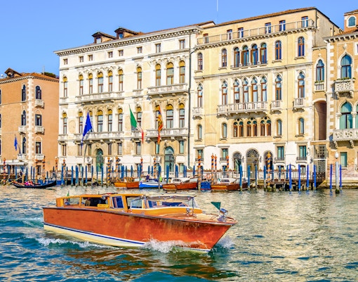 Venice water taxi cruising past historic buildings on the Grand Canal.