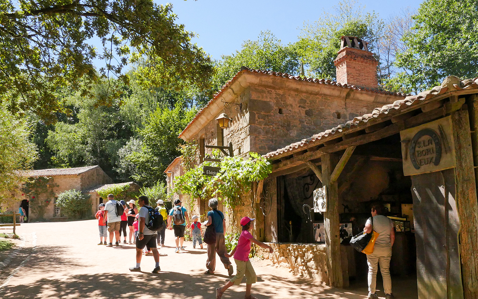 Visitors exploring rustic village at Puy du Fou Theme Park.