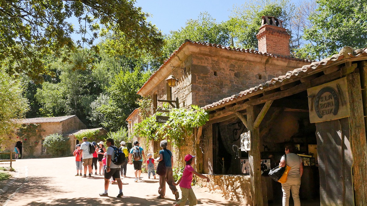 Puy du Fou Theme Park entrance with visitors entering under the stone archway, Fast-Track Entrance Tickets available