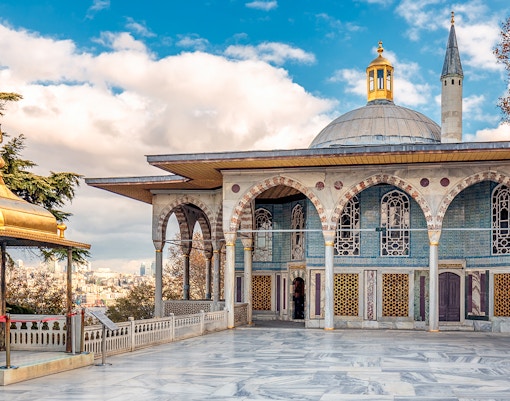 Topkapi Palace courtyard with tourists exploring historic architecture in Istanbul.