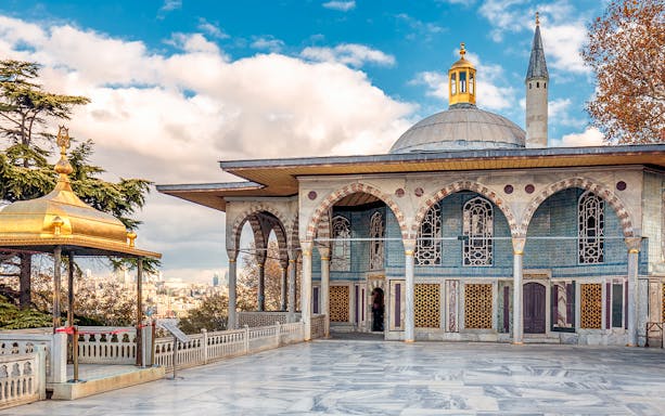 Courtyard of Topkapi Palace with ornate arches and a domed pavilion in Istanbul.