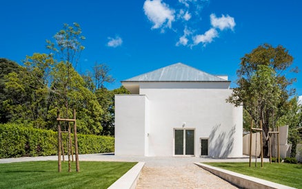 Modern white building at Serralves, Porto, surrounded by trees and a clear blue sky.