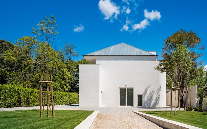 Modern white building at Serralves, Porto, surrounded by trees and a clear blue sky.