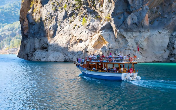 Boat tour near rocky cliffs on Kekova Sunken City tour, Turkey.