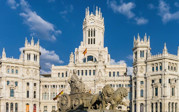 Cibeles Fountain and Palacio de Cibeles in Madrid on a sunny day.