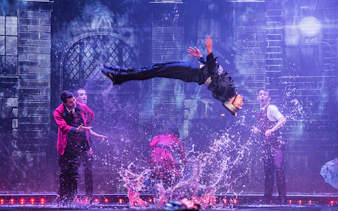 Performer mid-air during WOW: The Vegas Spectacular show with water effects.