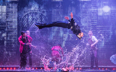 Performer mid-air during WOW: The Vegas Spectacular show with water effects.