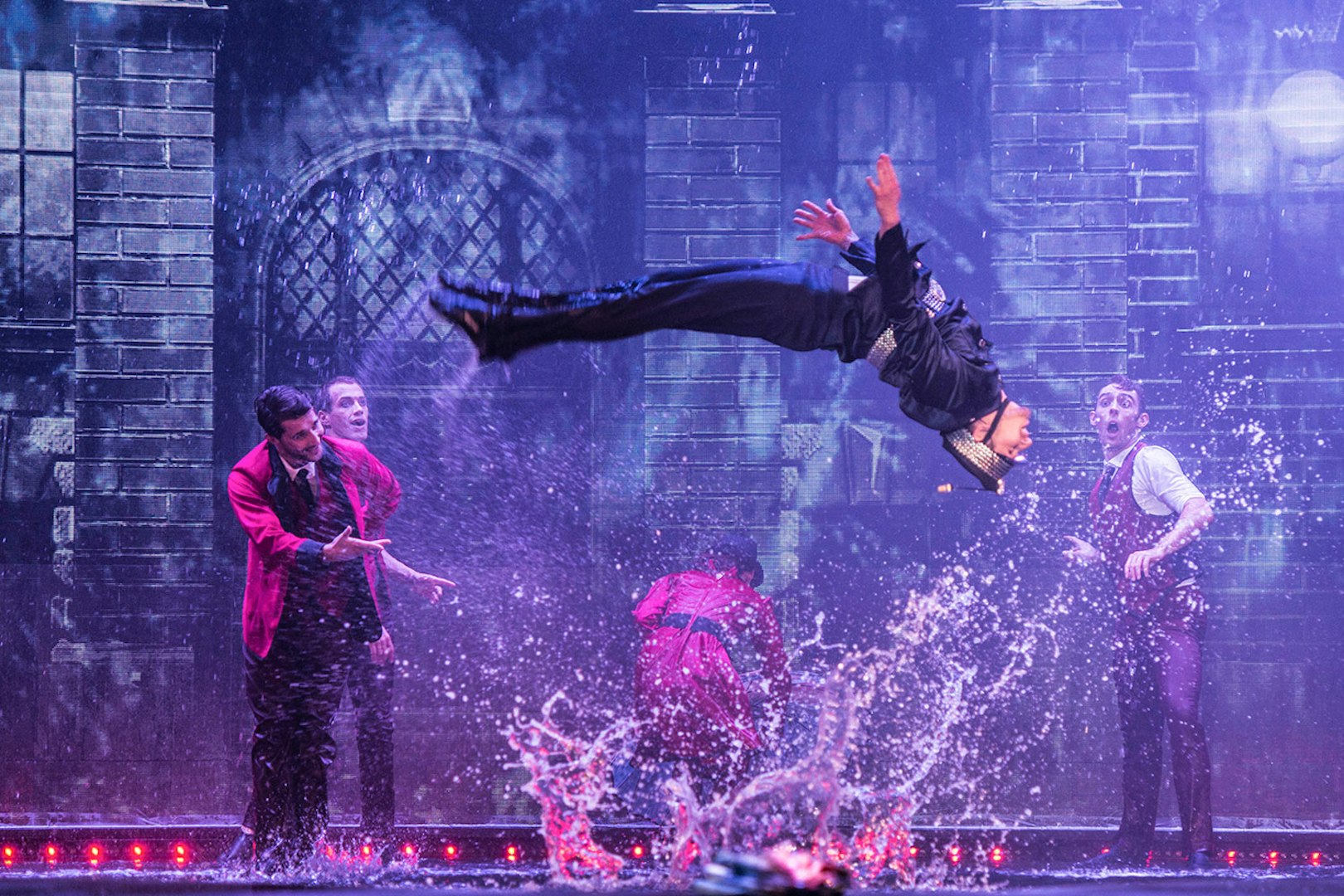Performer mid-air during WOW: The Vegas Spectacular show with water effects.