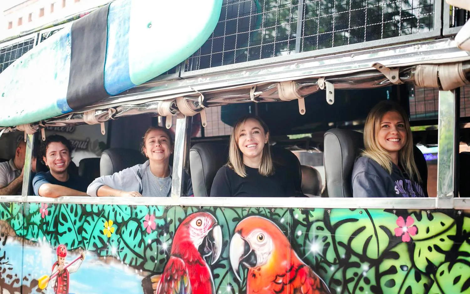 Guests smiling on a colorful bus during the Guatapé Adventure tour.