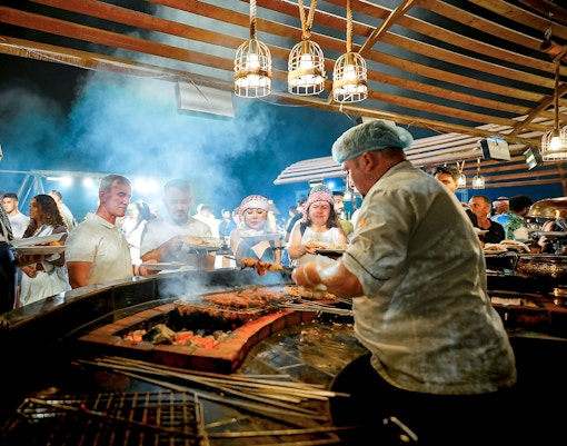Chef serving buffet food at Dubai desert safari experience.