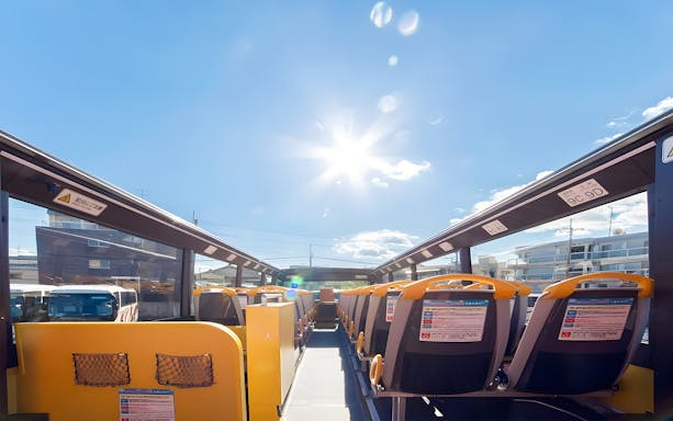 Open-top double-decker bus seats under clear sky on Osaka Sky Vista tour.