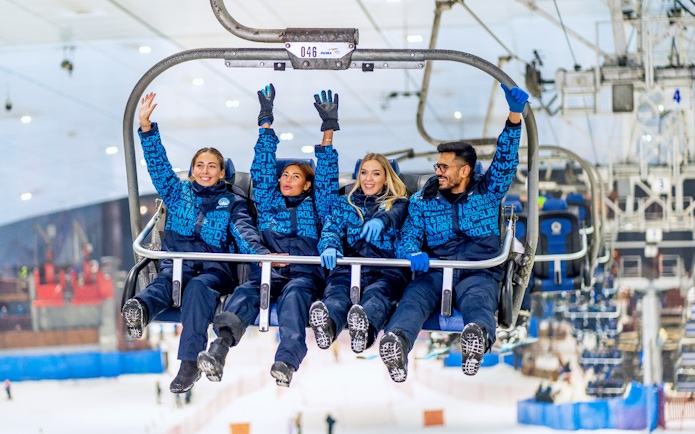 People enjoying a chairlift ride at Ski Dubai Snow Park.