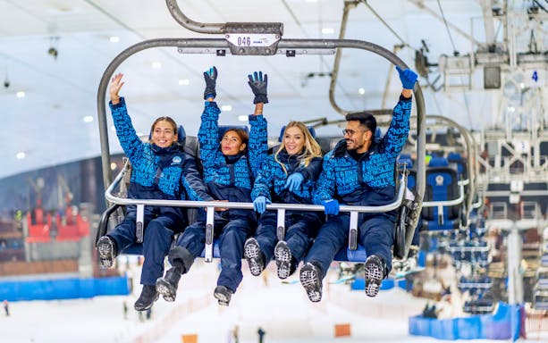 People enjoying a chairlift ride at Ski Dubai Snow Park.