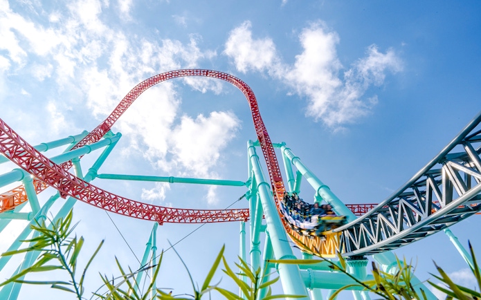 Xcelerator roller coaster at Knott's Berry Farm with steep loop and vibrant tracks.