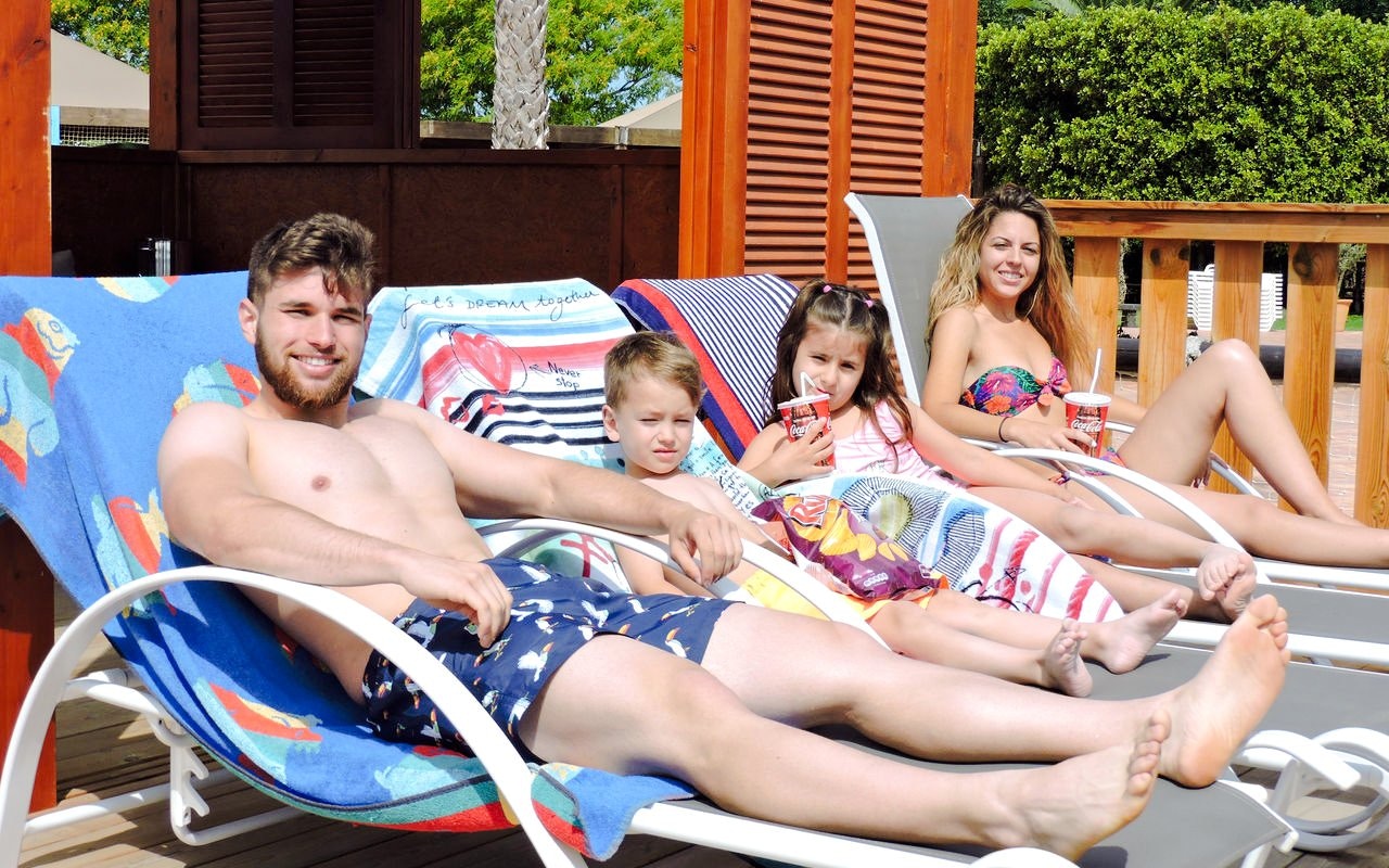Guests relaxing on sun loungers at Aquopolis Cullera water park.