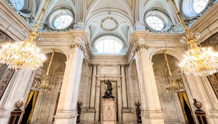 Royal Palace of Madrid entrance with tourists exploring the historic architecture.