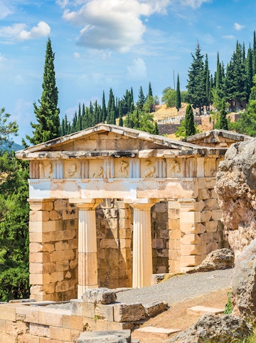 Ancient ruins at Delphi Archaeological Site, Greece, with stone columns and scenic landscape.