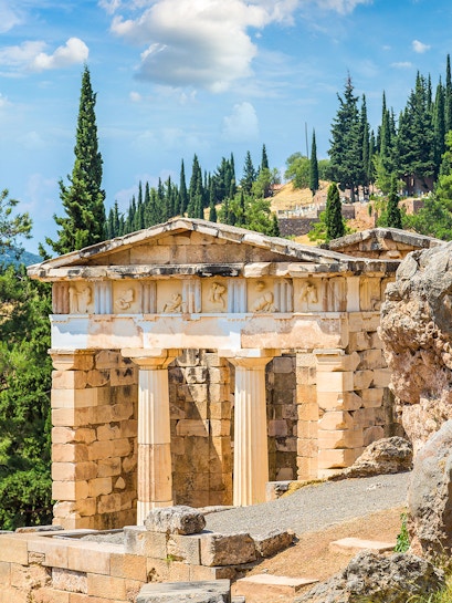 Ancient ruins at Delphi Archaeological Site, Greece, with stone columns and scenic landscape.