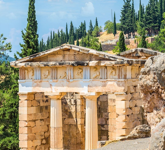Ancient ruins at Delphi Archaeological Site, Greece, with stone columns and scenic landscape.