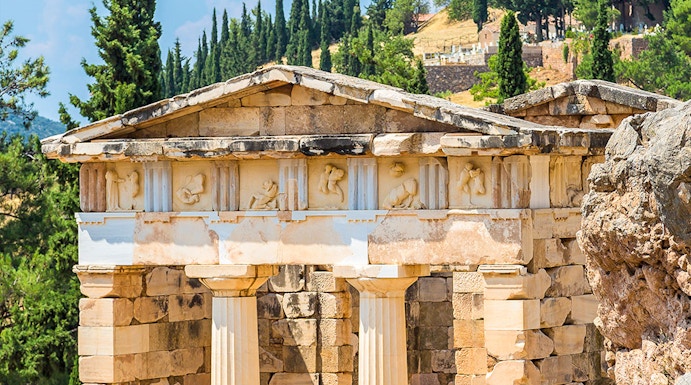 Ancient ruins at Delphi Archaeological Site, Greece, with stone columns and scenic landscape.