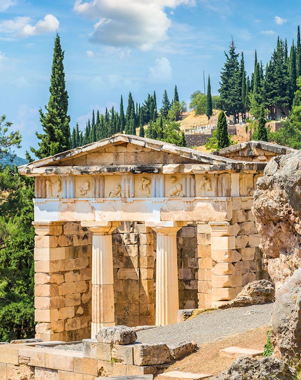 Ancient ruins at Delphi Archaeological Site, Greece, with stone columns and scenic landscape.