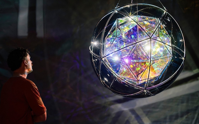 Man observing Olafur Eliasson's geometric light sculpture at Gallery of Modern Art.