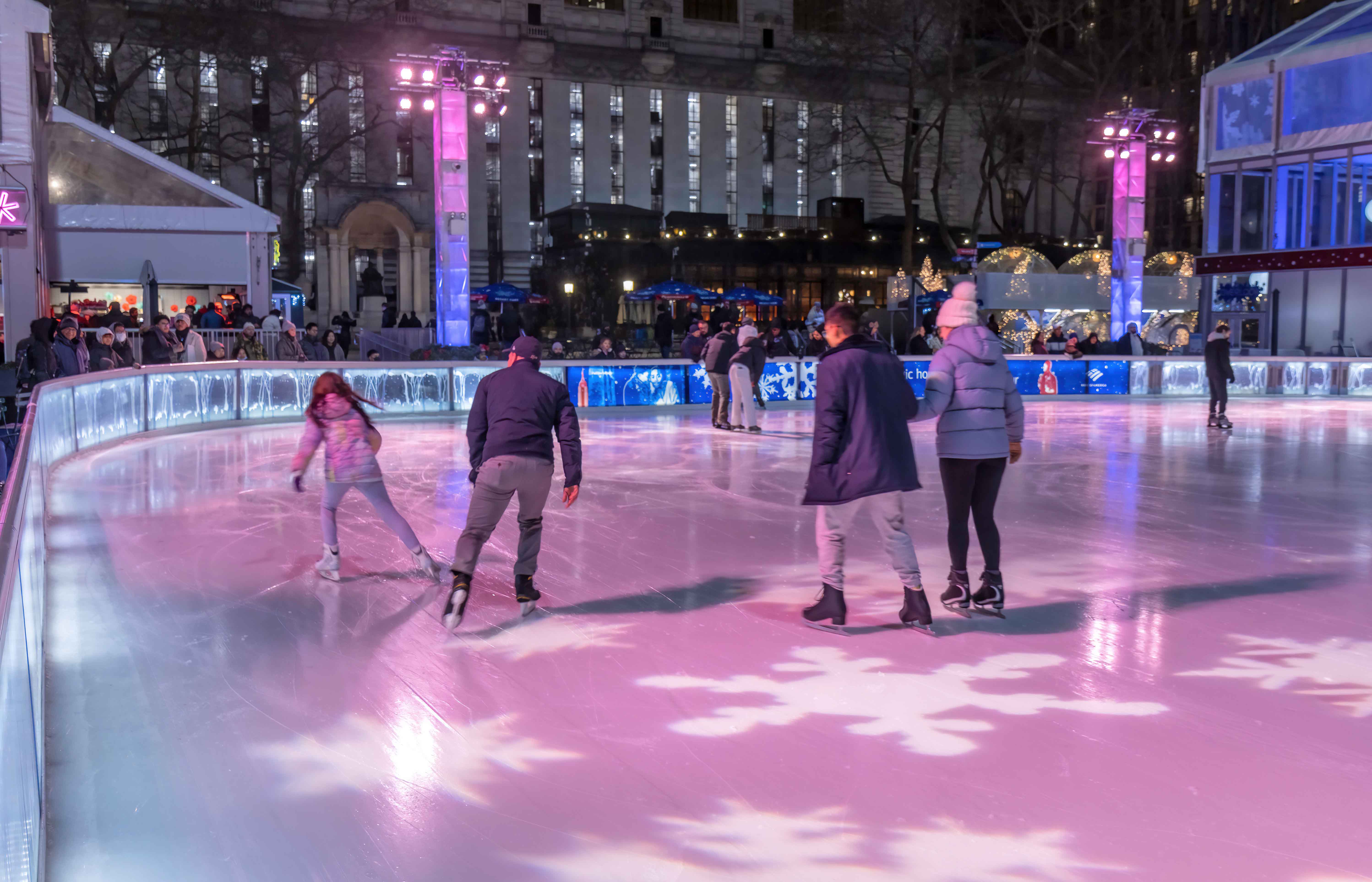 Ice skaters enjoying the rink at Bryant Park during winter in New York City.