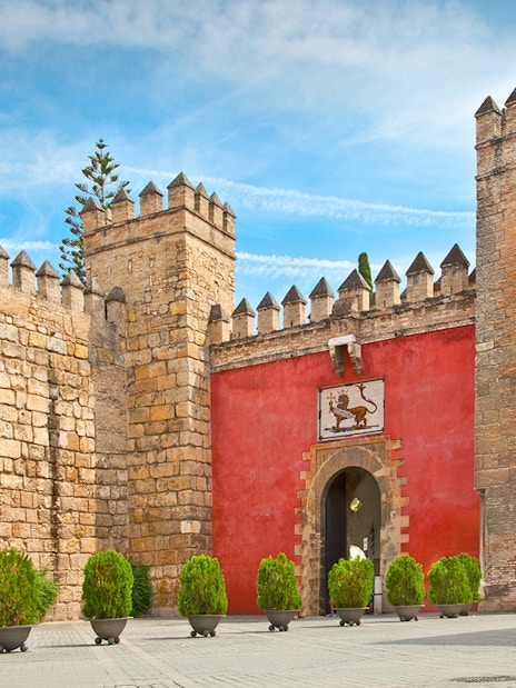 Tourists in a horse-drawn carriage at the entrance of Alcazar of Seville, Spain.