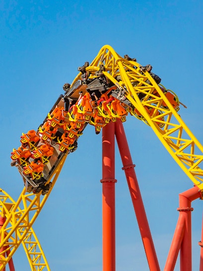 Roller coaster loop at Six Flags: Great America with riders in orange seats.