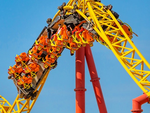 Roller coaster loop at Six Flags: Great America with riders in orange seats.