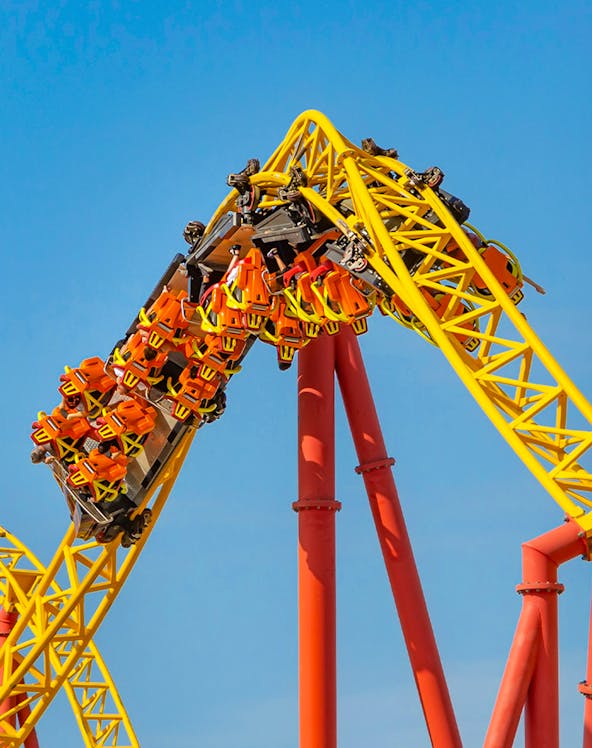Roller coaster loop at Six Flags: Great America with riders in orange seats.