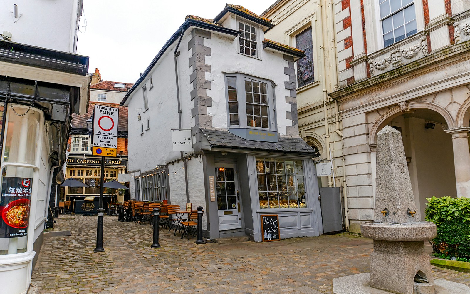 Crooked House of Windsor with outdoor seating and pedestrian zone sign.