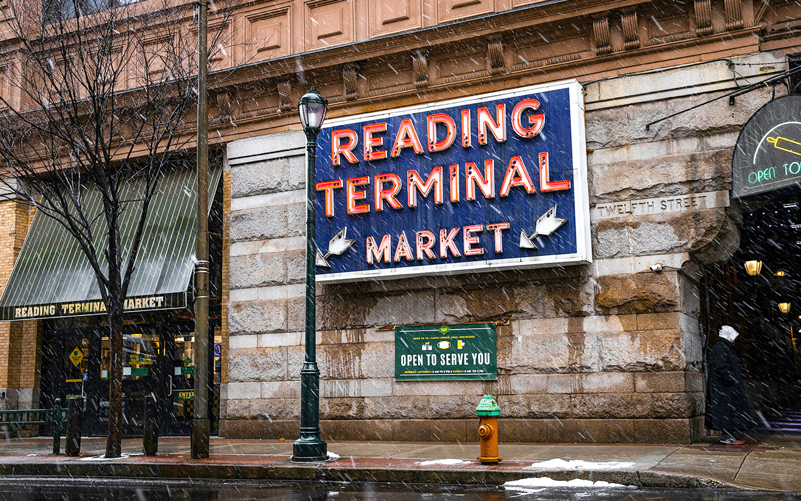 Reading Terminal Market entrance with neon sign in snowy Philadelphia.