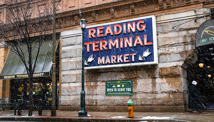 Reading Terminal Market entrance with neon sign in snowy Philadelphia.