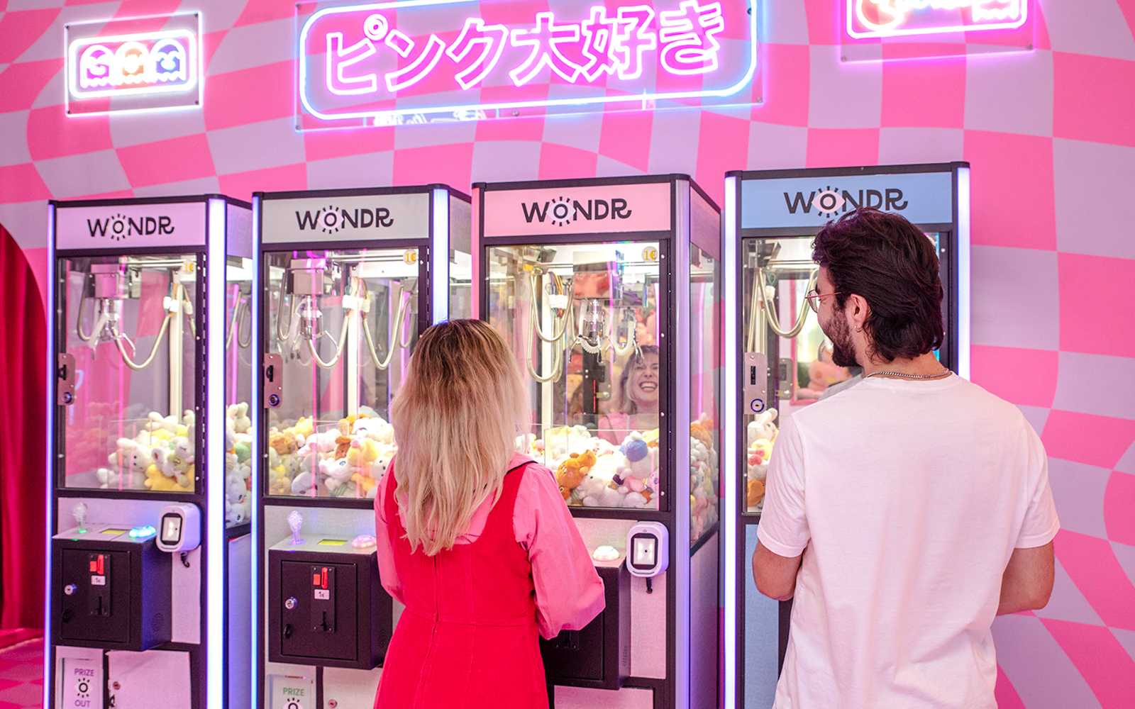 Guests playing claw machines at WONDR Experience in Amsterdam.