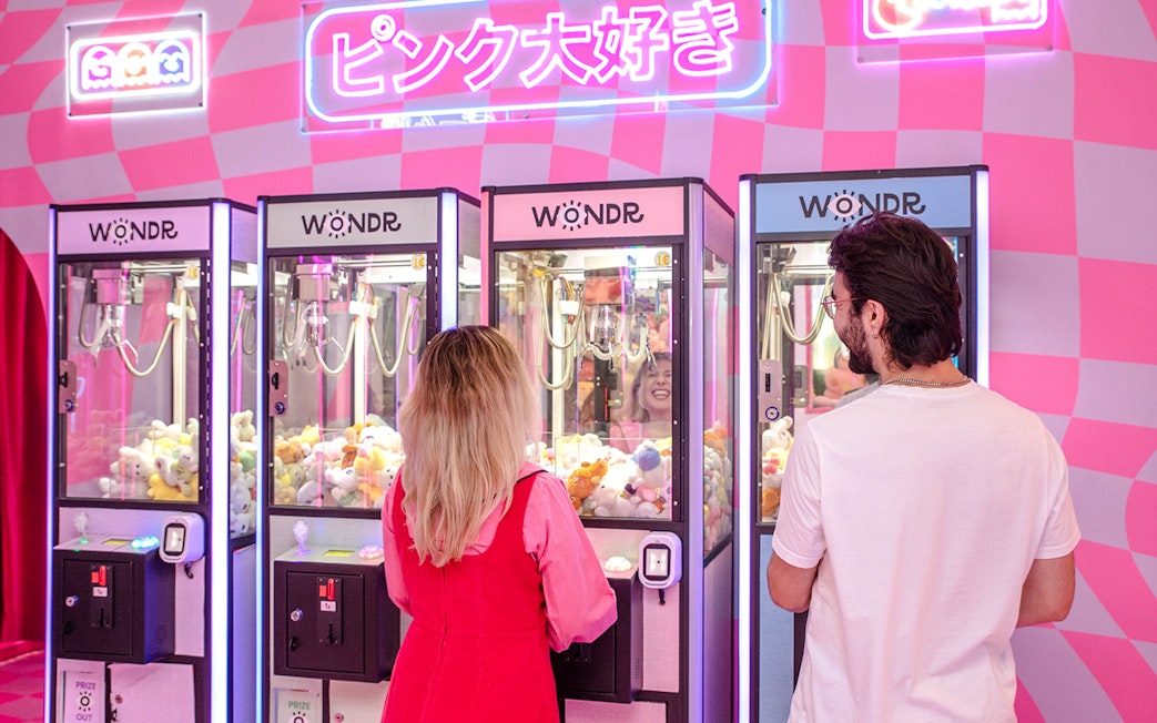 Guests playing claw machines at WONDR Experience in Amsterdam.