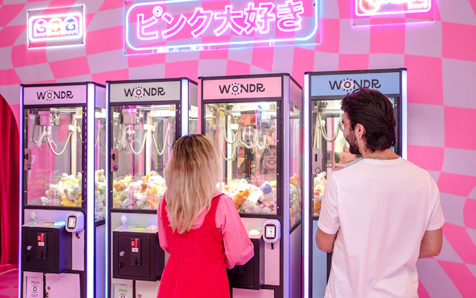 Guests playing claw machines at WONDR Experience in Amsterdam.