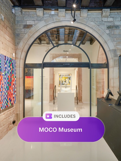 Entrance of MOCO Museum in Barcelona with colorful artwork and reception desk.