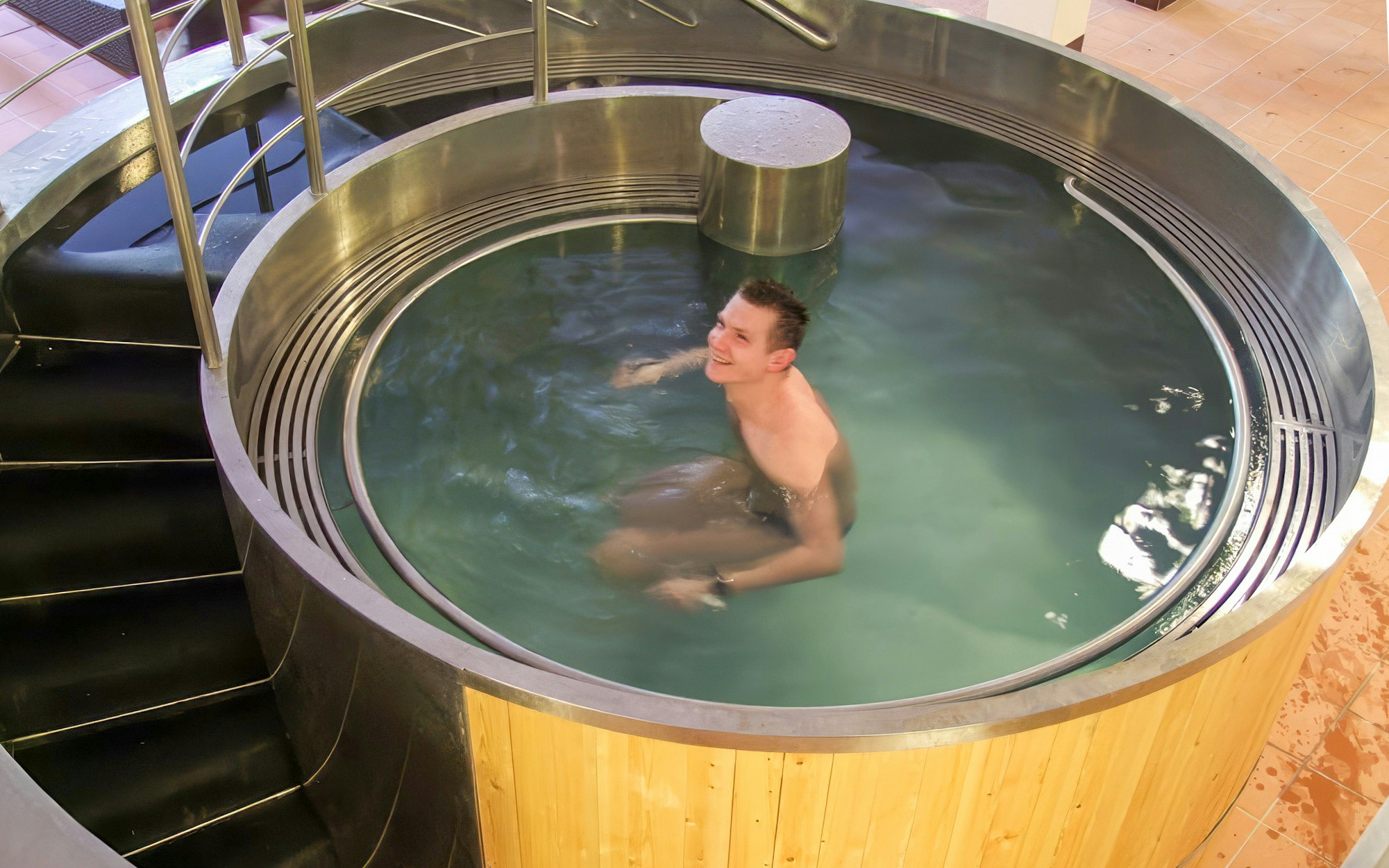 Man relaxing in a circular indoor pool at Lukacs Bath, Budapest.