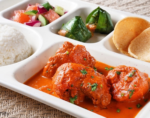Traditional meal with curry, rice, salad, and snacks at Disneyland Hong Kong.