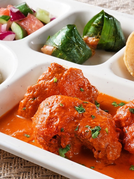 Traditional meal with curry, rice, salad, and snacks at Disneyland Hong Kong.