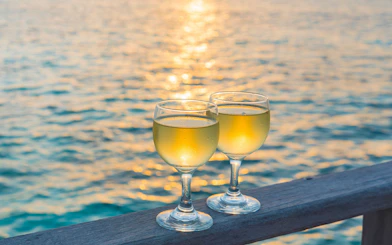 Two wine glasses on a railing with a sunset over the sea in Split, Croatia.