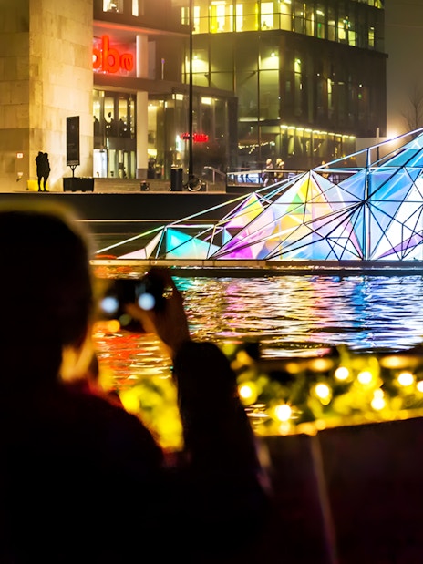Guests viewing illuminated art installation on Amsterdam Light Festival Cruise.