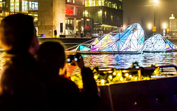 Guests viewing illuminated art installation on Amsterdam Light Festival Cruise.