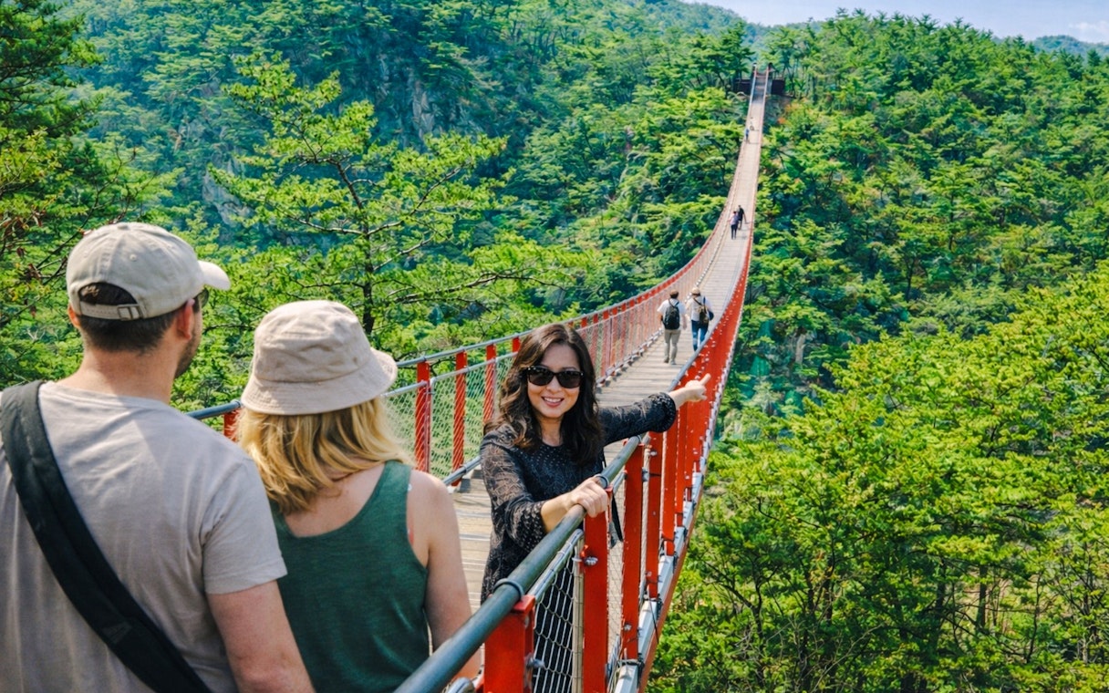 Private guide with tourists on Gamaksan Suspension Bridge, South Korea.