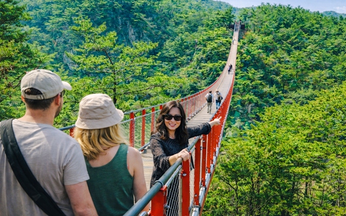 Private guide with tourists on Gamaksan Suspension Bridge, South Korea.