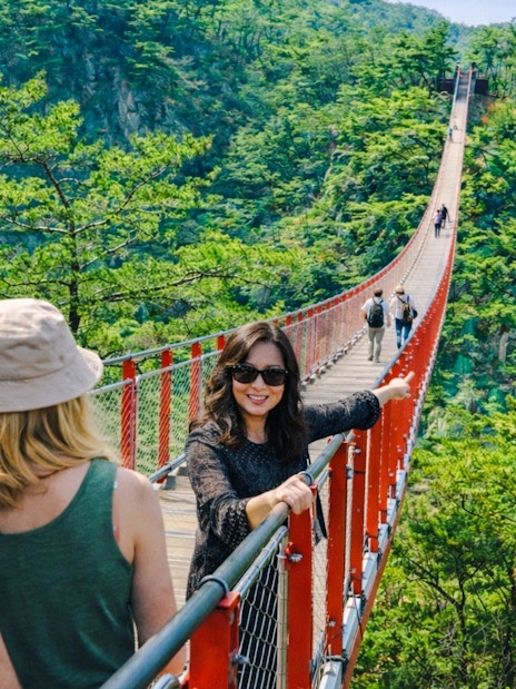 Private guide with tourists on Gamaksan Suspension Bridge, South Korea.