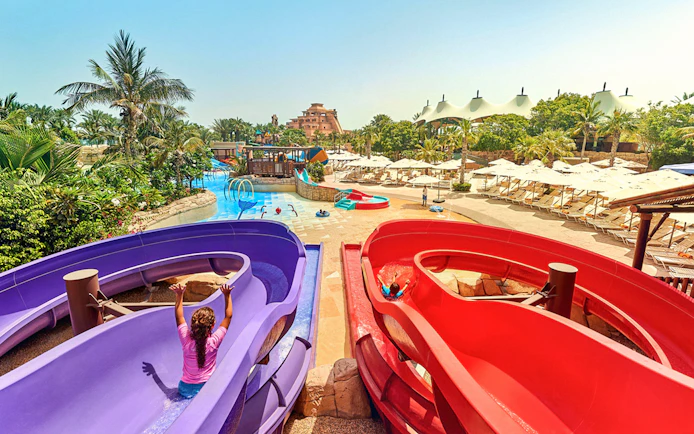 Children enjoying water slides at Aquaventure Waterpark, Dubai.