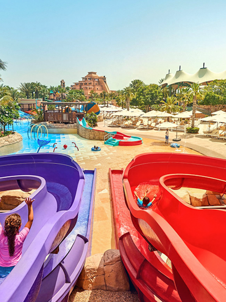 Children enjoying water slides at Aquaventure Waterpark, Dubai.